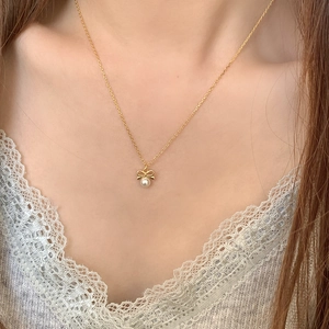 Elegant gold S925 silver necklace with bow pendant and round white pearl on model