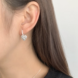 Detailed close-up of S925 silver hoop earrings with diamond-set heart pendants on ear