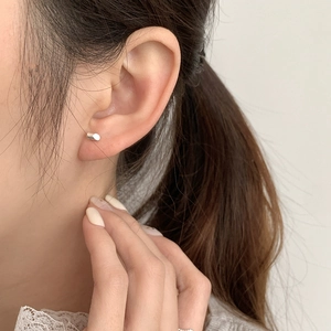 Minimalist S925 sterling silver cylinder stud earring worn on earlobe for daily fashion
