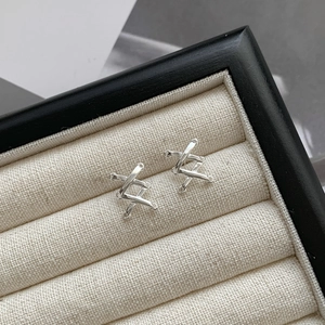 Macro shot of silver S925 sterling silver crisscross lattice stud earrings in a jewelry box