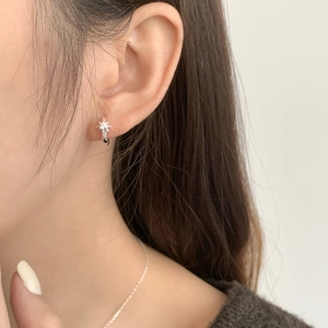 Orecchino a stella minimalista in argento S925 con zircone indossato sul modello
