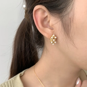 Elegant gold lace stud earrings with pearls and S925 silver base worn by a female model