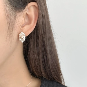 Close-up of elegant S925 silver lace earrings with white pearls worn by a model