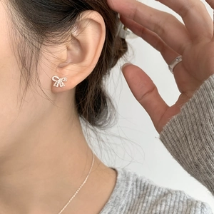 Elegant S925 sterling silver hollow lace bow stud earrings worn by model for daily style