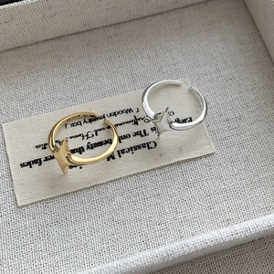 Detail of adjustable silver and gold S925 rings with minimalist four-point star design