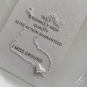 Macro shot of S925 sterling silver stamp on heart pendant bracelet with white zircon stone
