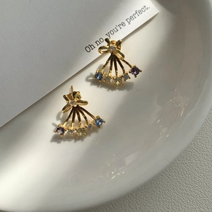 Detail of S925 silver butterfly earrings with colorful zircons on a ceramic plate