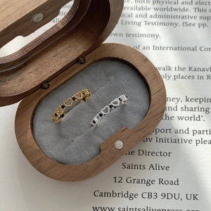 Detail of vintage heart hollow rings with black zirconia in a wooden jewelry box