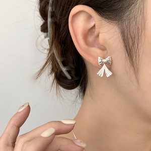 Boucles d'oreilles nœud en argent S925 avec perle portées par un mannequin