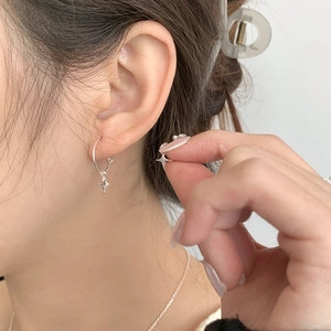 Close-up of S925 sterling silver hoop earrings with asymmetric star pendants on a model