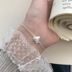 Detail of S925 sterling silver heart bracelet with zircon on model's wrist