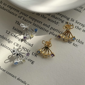 Close-up of butterfly earrings with multi-color zircon stones and gold plating