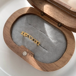 Detail of vintage hollow heart ring with black zircons in a wooden jewelry box