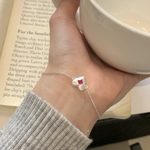 Minimalist S925 sterling silver heart bracelet with red zircon worn on a woman's wrist