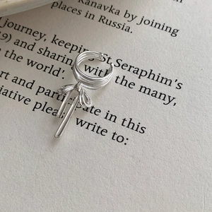 S925 sterling silver ballet bow ear cuff with long metallic tassels on vintage book