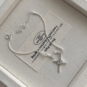 Macro detail of S925 sterling silver four-pointed star cross bracelet with lobster clasp
