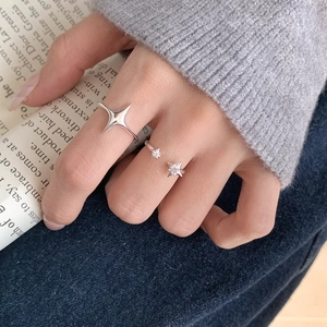 Detail view of double star S925 sterling silver rings worn on model hand with cozy vibes