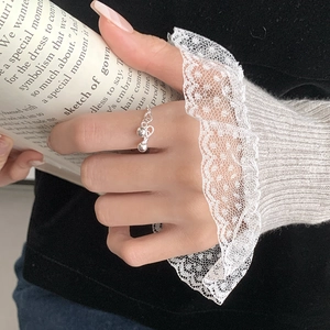 Detail of twisted silver band ring with two dangling beads on elegant model hand