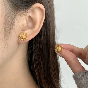 Close-up of elegant hollow floral 925 sterling silver earrings worn by a model