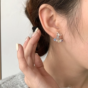 Silver butterfly earrings with colorful zircon stones on model ear in close-up view