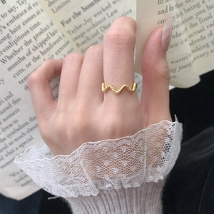 Gros plan d'une bague dorée en argent S925 avec une élégante texture de vague torsadée