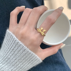 Detailed view of an elegant golden bow ring worn on hand for a minimalist lifestyle look