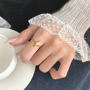 Close-up of a gold star-shaped S925 silver ring worn in an elegant lifestyle setting