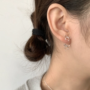 Elegant S925 sterling silver ribbon bow earrings worn by model for a refined look
