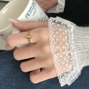 Close-up of golden double star ring on hand with elegant French style lifestyle background