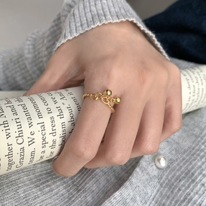 Detailed shot of S925 sterling silver twist ring with gold double bell bead charms
