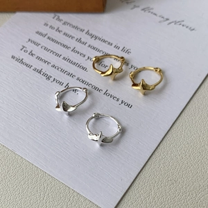 Detailed view of minimalist S925 sterling silver star hoop earrings in gold and silver