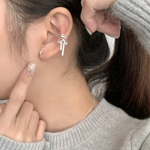 Close-up of S925 silver ballet bow ear cuff and star stud on model's ear