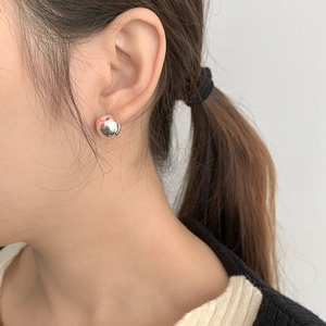 Close-up of S925 silver ball stud earring with pink bow design on female ear
