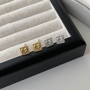 Close-up of S925 sterling silver square grid heart studs in gold and silver finishes