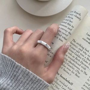 S925 sterling silver ring with vertical brushed texture and white crystals on finger