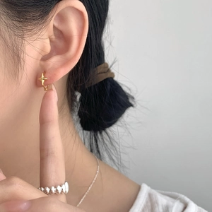 Detail shot of model wearing a minimalist gold star hoop earring in 925 sterling silver