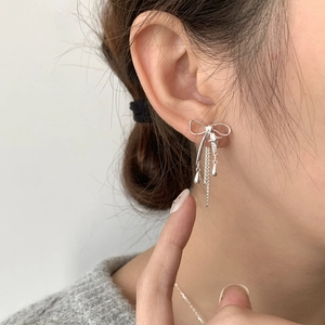 Gros plan de boucles d'oreilles nœud en argent S925 avec longs pompons sur un mannequin