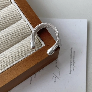 Macro shot of S925 sterling silver multilayer woven mesh ring texture on wooden stand