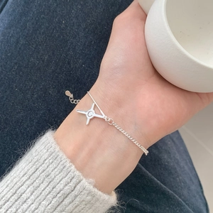 Detail of S925 silver star bracelet with zircon pendant worn on wrist with denim outfit