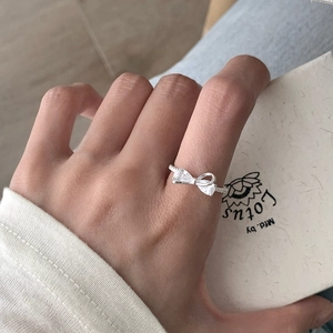 Macro shot of S925 silver bow ring with zircon stones worn on model's finger