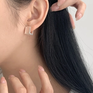 Side view of a person wearing minimalist S925 silver square hoop earrings with stripe detail