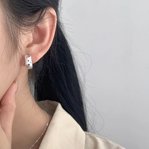 Vintage 925 silver hoop earrings with colorful zircon starburst inlays worn by a model