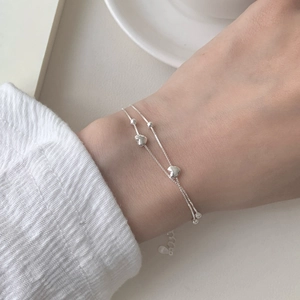 Close-up of S925 sterling silver double-layer bracelet with heart charms and beads