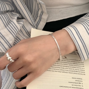 Detailed view of 925 sterling silver three-layer snake chain bracelet on a model's wrist