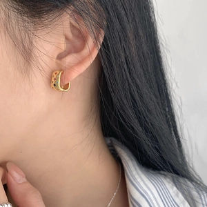 Detail of 925 silver gold-plated hoop earrings with multi-color zircon star setting