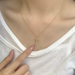 Collier croix en argent S925 doré avec texture perlée sur une chaîne fine minimaliste