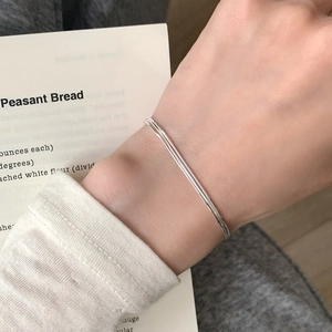 Minimalist triple-layer S925 sterling silver snake chain bracelet worn on a woman's wrist
