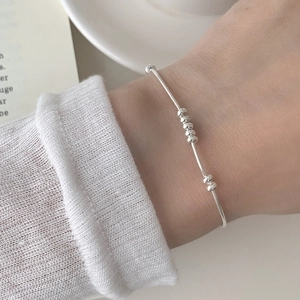 Close-up of a minimalist S925 sterling silver snake chain bracelet with sliding beads