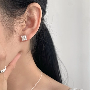 Close-up of S925 sterling silver square stud earrings with heart pattern on model