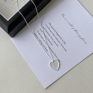 Detail of S925 sterling silver heart necklace with frosted texture and beaded edge